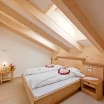 Camera da letto accogliente con tetto a travi in legno e letto matrimoniale