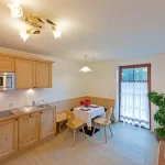 Cucina moderna con angolo pranzo, piante e illuminazione soffusa