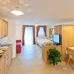 Open space accogliente con cucina, zona pranzo e letto matrimoniale