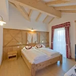 Camera da letto in stile alpino con letto matrimoniale e TV